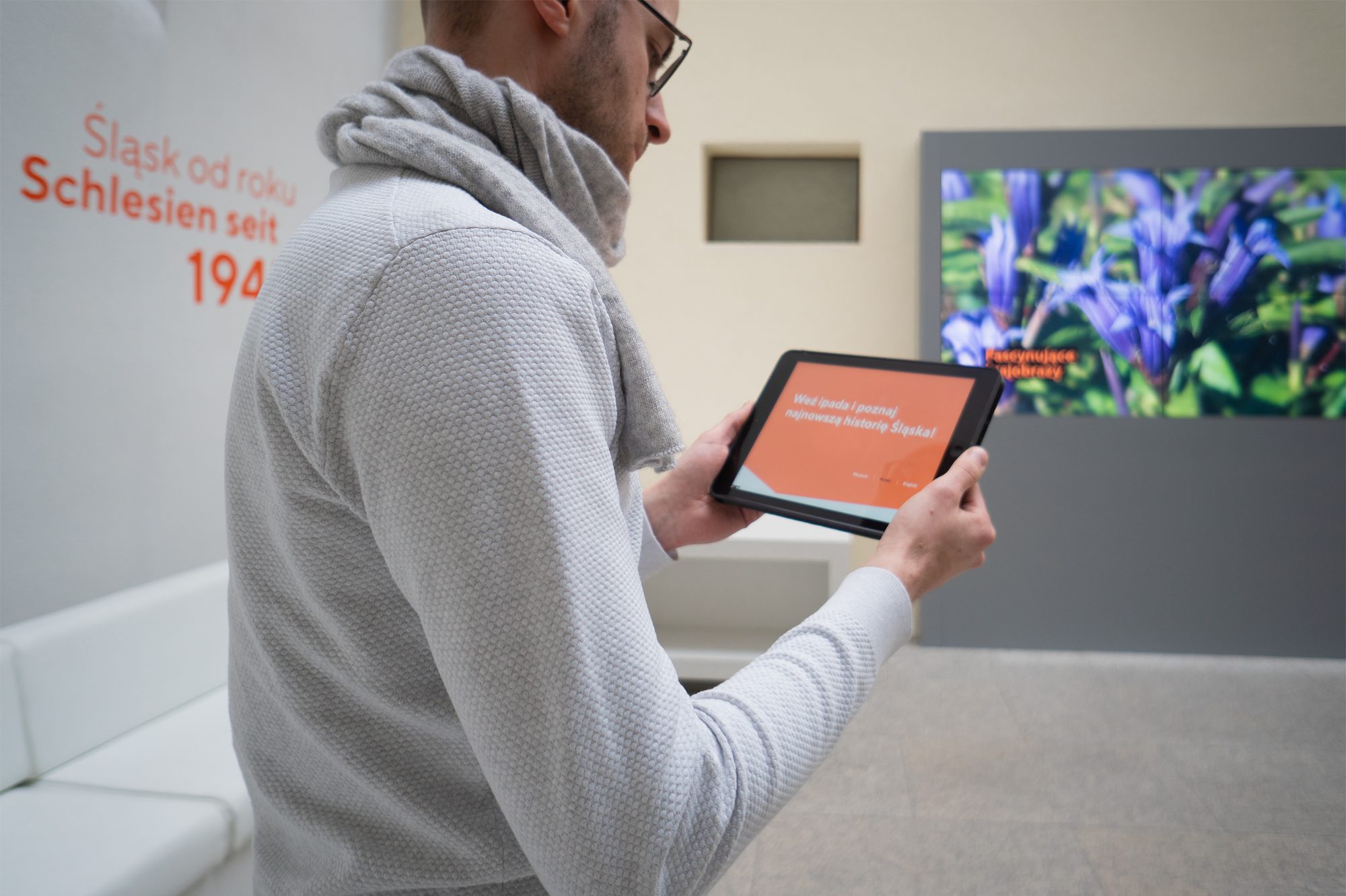 Besucher bei der App-Interaktion an der Medienstation, Ausstellung Schlesien seit 1945